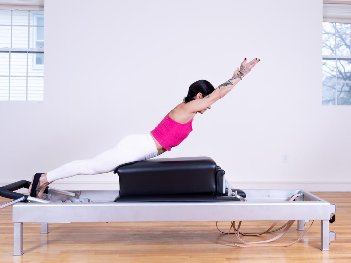 A student in a leg-lift position on the Pilates reformer.