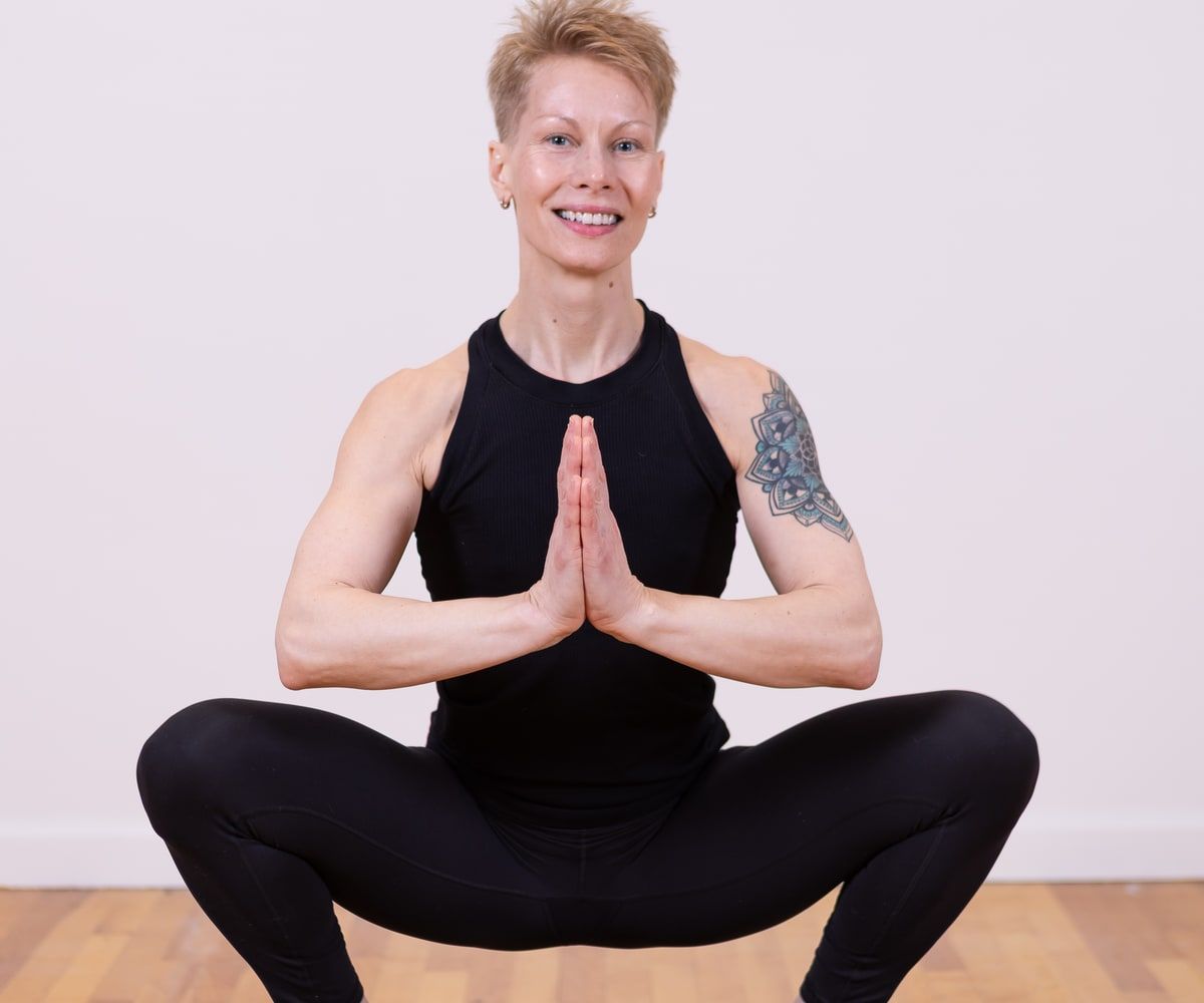 MJ Nitschke seated cross-legged with hands at heart centre.