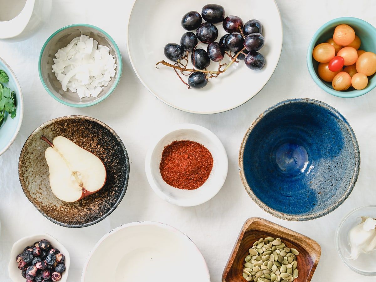 Bowls of fresh berries and grains on a table.