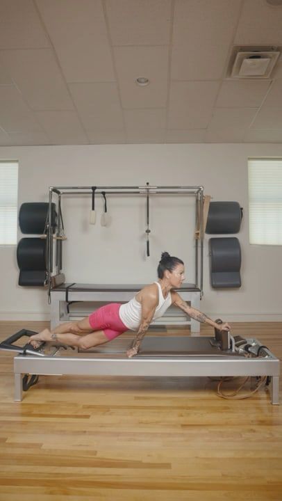 Karina standing beside the reformer, about to begin. Video: Reformer.